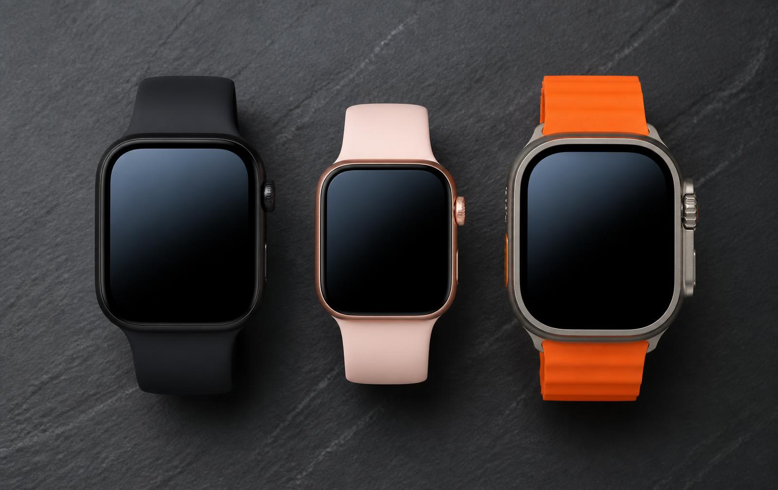 Drie vierkante smartwatches in zwart, rosegoud en titanium naast elkaar op leisteen
